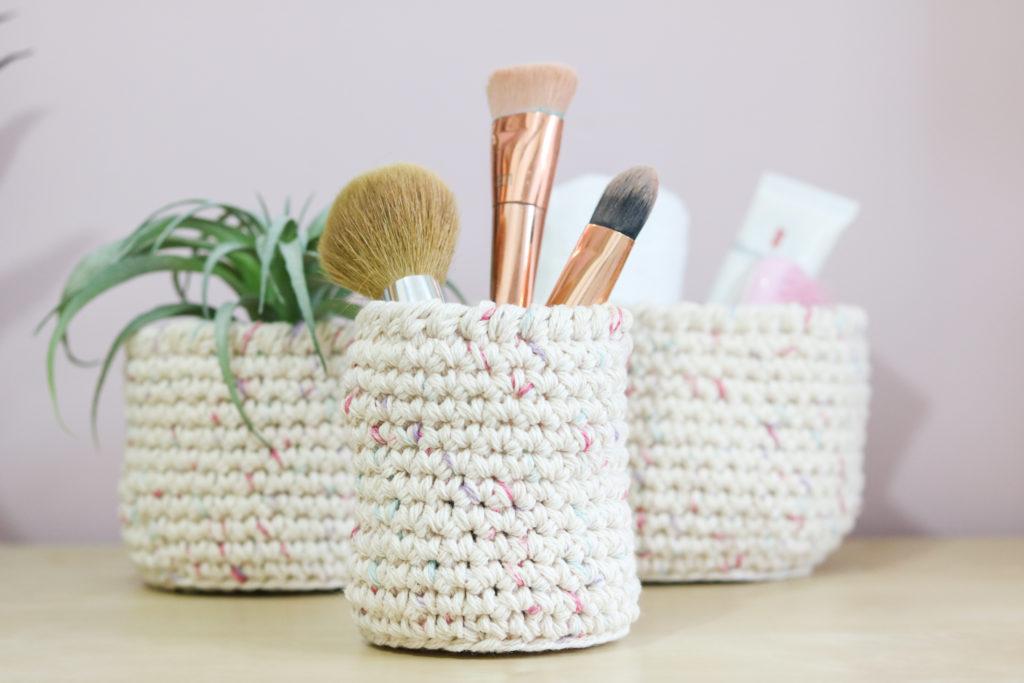 3 nesting baskets filled with a plant, make up brushes and self care supplies.