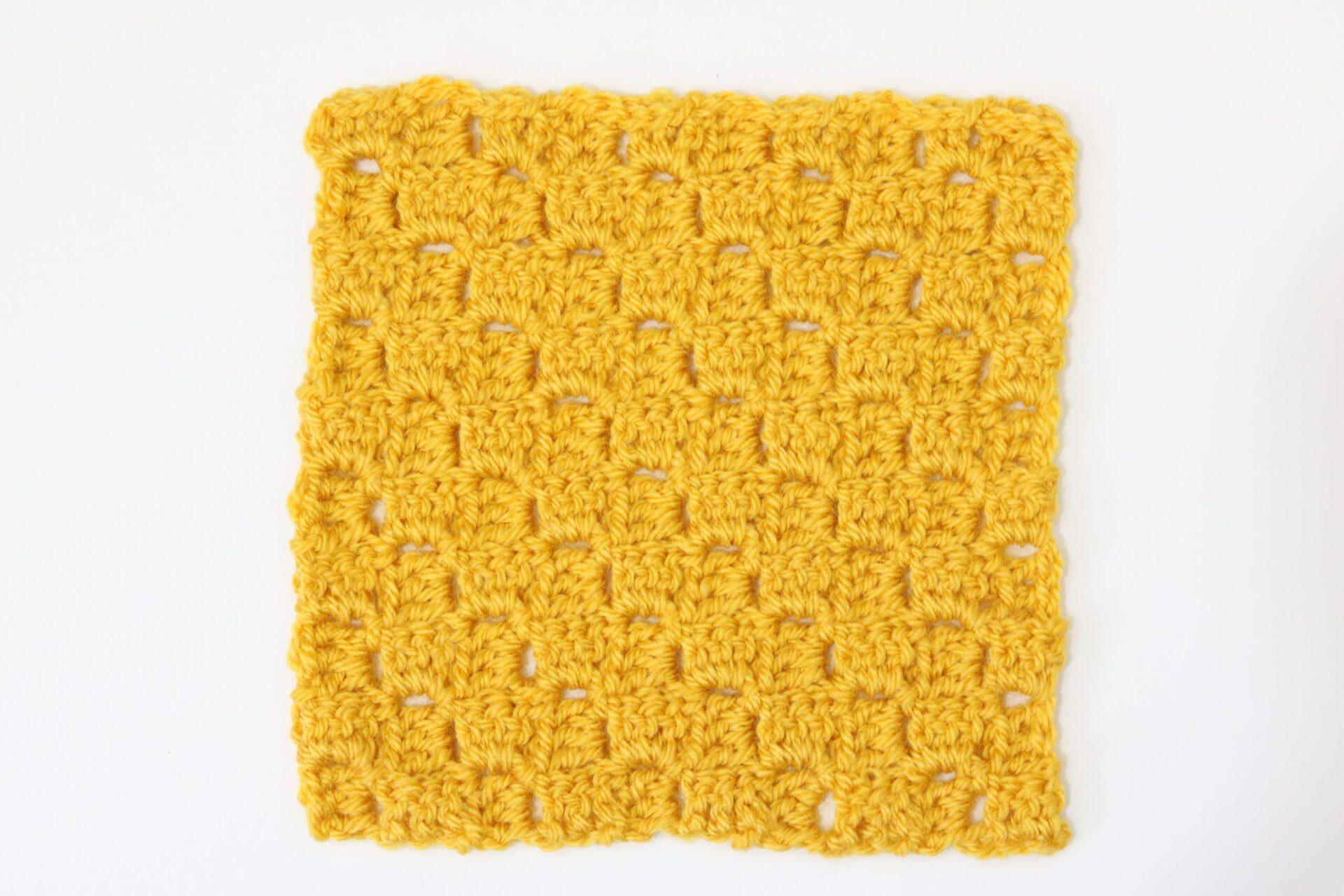 A swatch of corner to corner crochet on a white background made into a square.