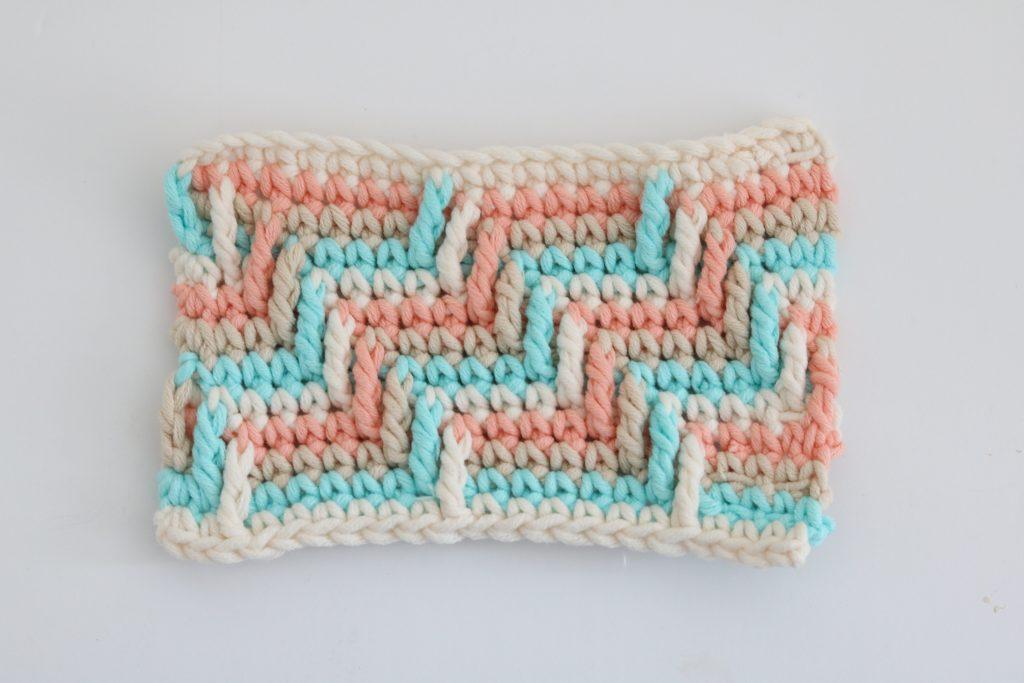 A swatch of Apache Tears crochet stitch in pastel coloured yarn.