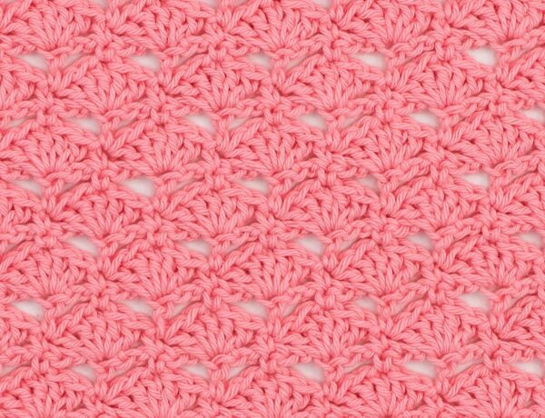 close up of a crochet swatch showing the little fans stitch in pink yarn
