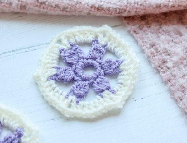 Flower hexagon crochet on a white background with some pink crochet.
