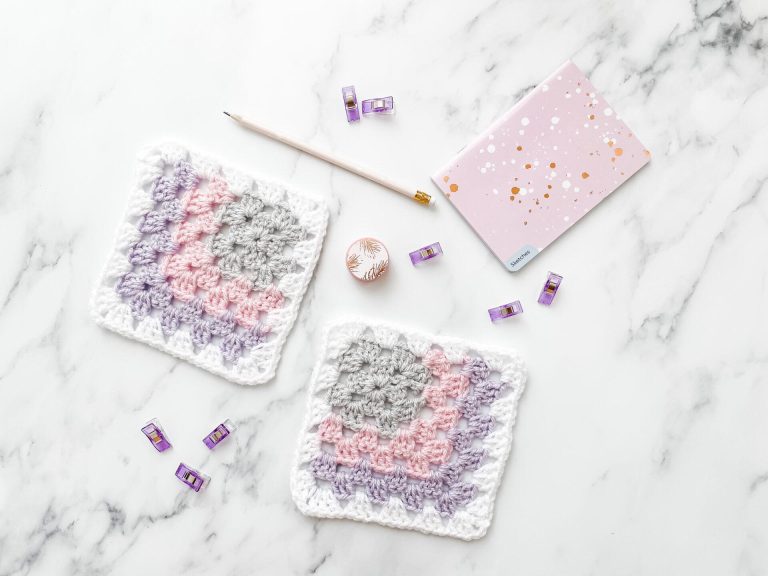 Mitered granny square on a marble background with stationery.