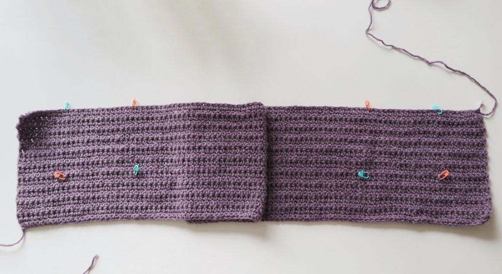 A swatch in purple yarn showing the construction of the crochet cardigan