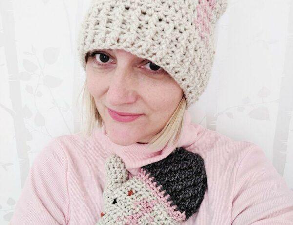 a women wearing a crochet hat and mittens made in pink and cream yarn.