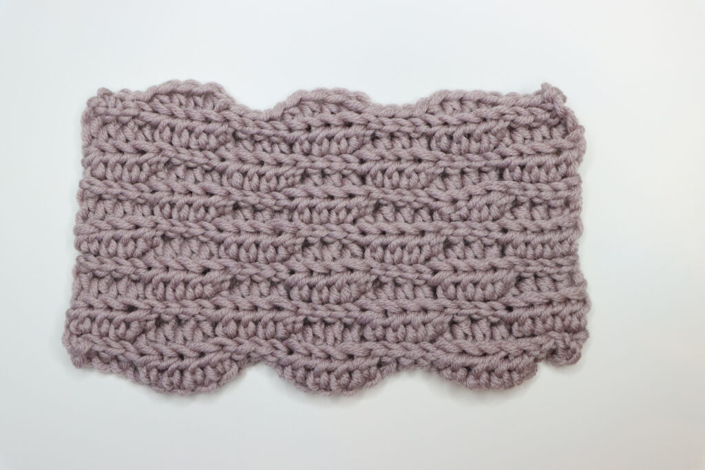 A swatch showing the back of the Almond Ridges crochet pattern made in mauve yarn.