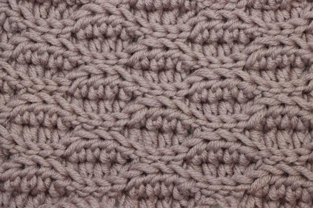 A swatch of the Almond Ridges crochet pattern made in mauve yarn.