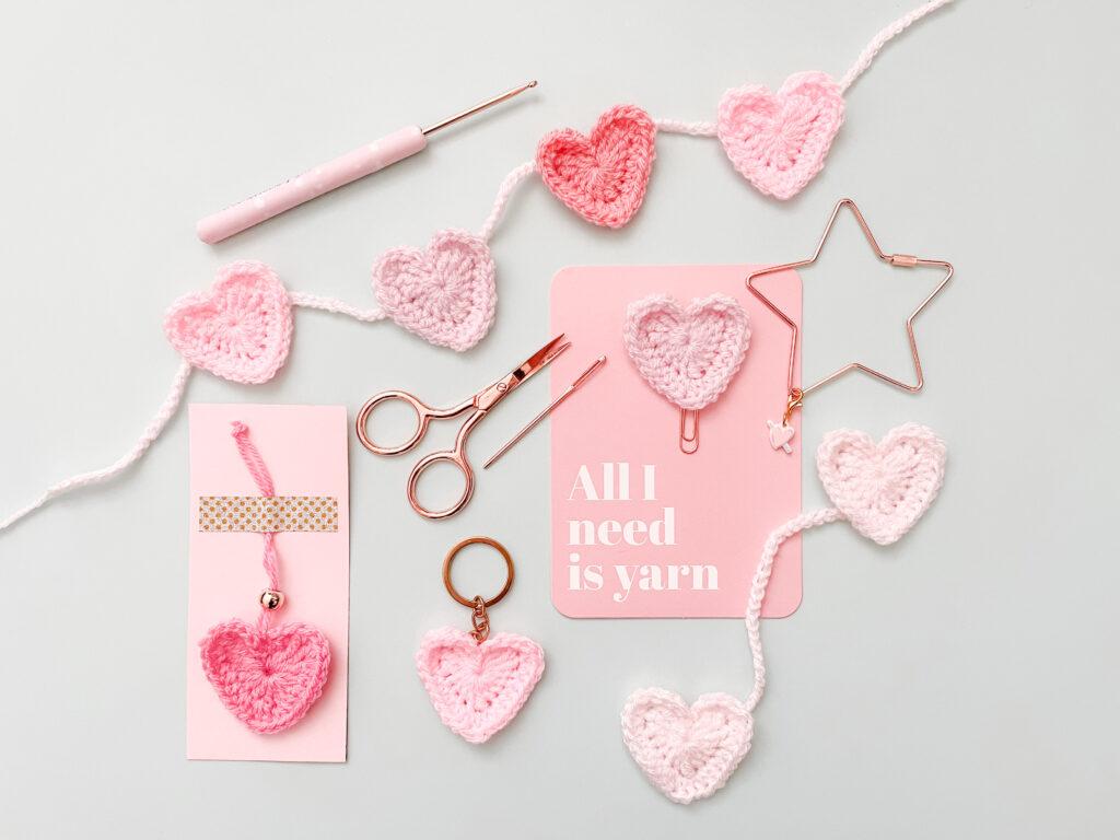 Flat lay of crochet hearts with rose gold scissors, keyring and 'all I need is yarn' on a card.