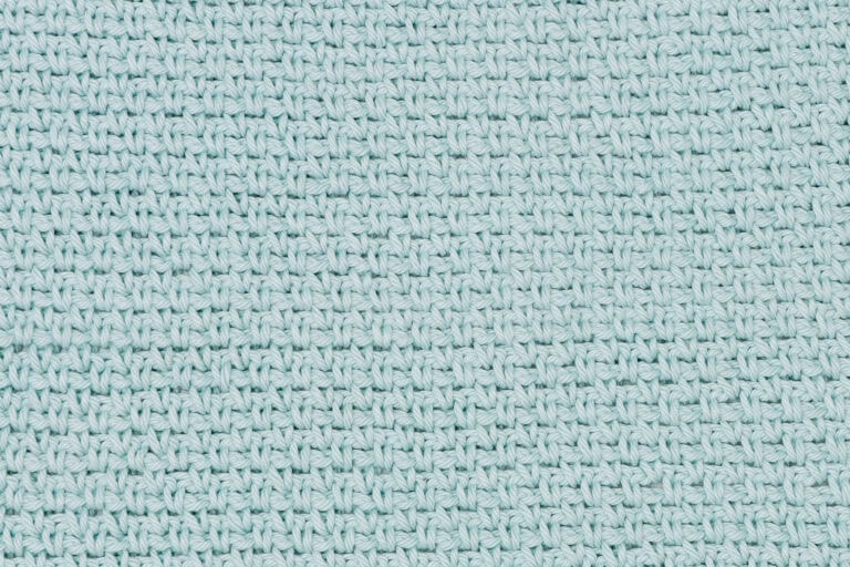 close-up image of a crochet swatch in a light blue yarn showing the moss stitch