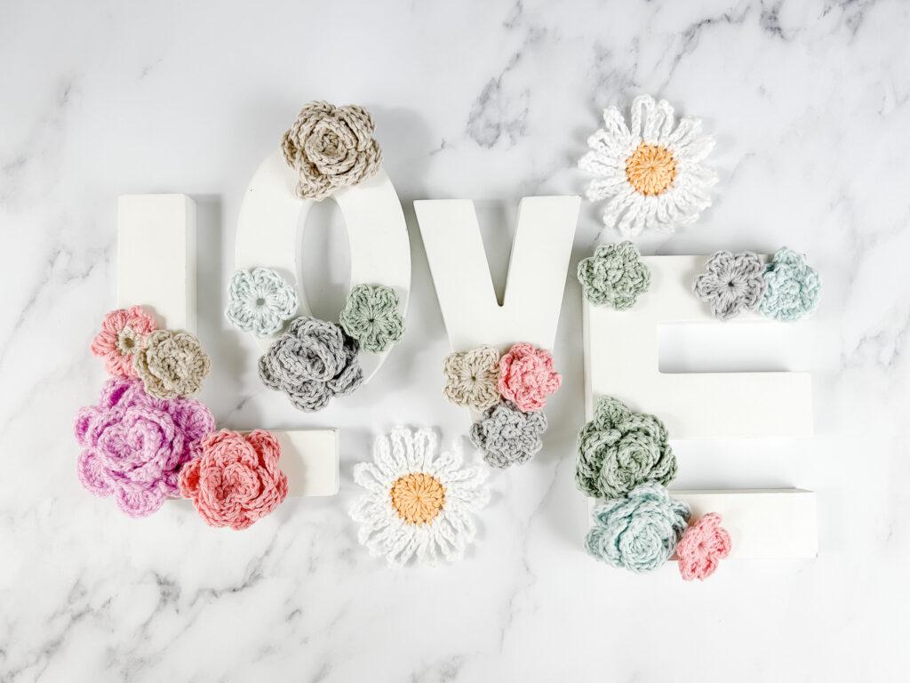Crochet flowers laid on the word 'Love'