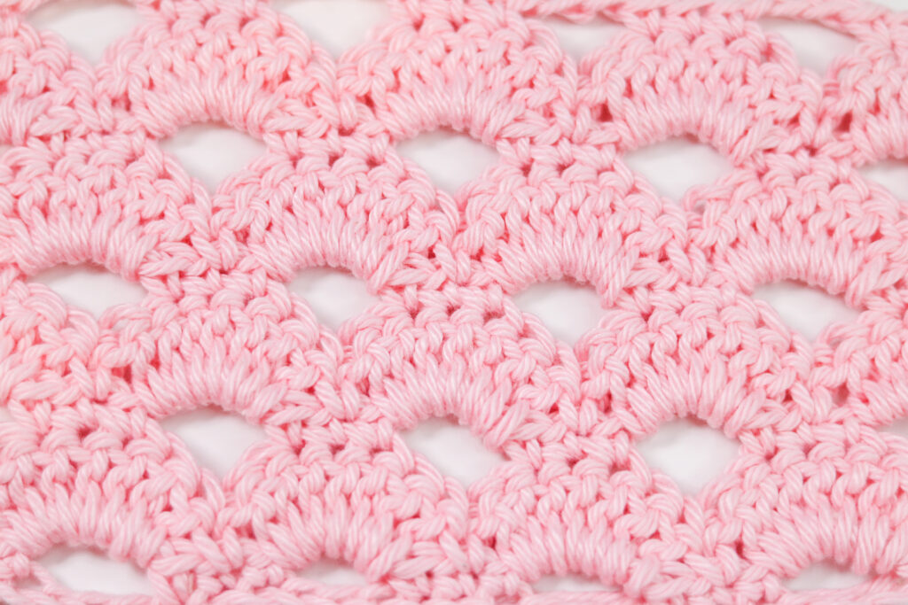 a flat lay of a pink crochet swatch of the arcade stitch.