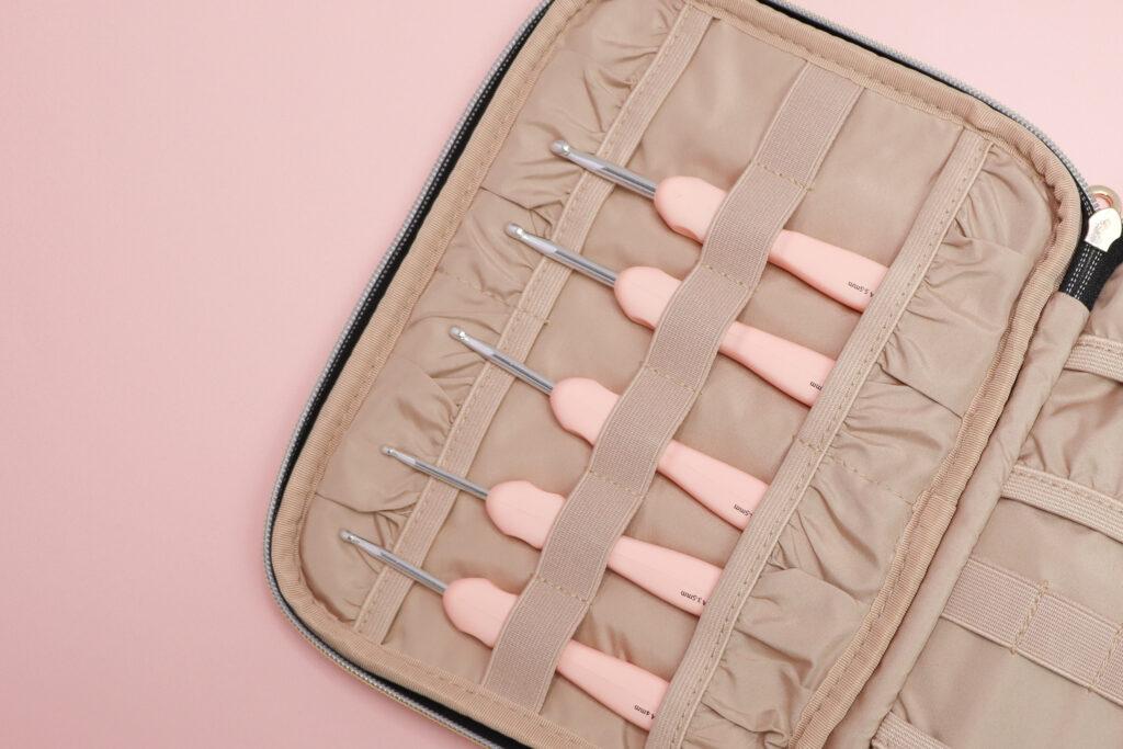 a flat lay image of five crochet hooks inside a crochet storage case to show how you can travel with your crochet hooks. 