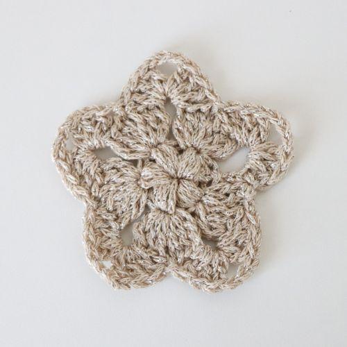 a flat lay image of a crochet star made using a sparkly cotton DK yarn to show how it looks using this yarn and a 4mm hook. 
